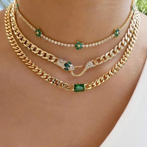 Three-layer gold stacked necklace featuring green flower and snake head accents