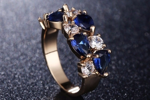 Détail macro d'une bague en or rose avec saphirs bleus poire et zircons ronds brillants