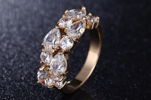 Détail macro d'une bague en or rose avec zircons ronds et en goutte en serti pavé
