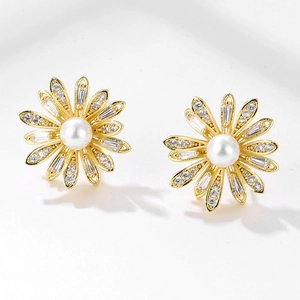 Elegant gold daisy earrings with central pearl and sparkling cubic zirconia petals