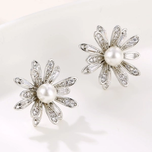 Elegant daisy stud earrings with sparkling crystals and a white pearl center on silver