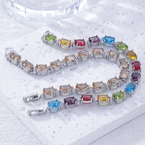 Silver tennis bracelets with colorful oval zircons in blue, purple, and green on stone