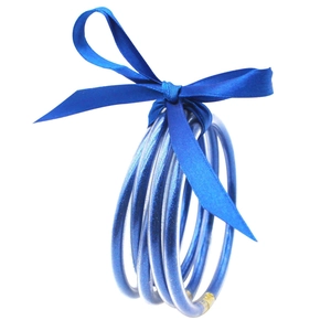 Detalle de brazaletes de silicona con purpurina azul y un lazo decorativo de satén azul
