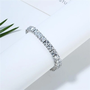 Macro shot of silver tennis bracelet featuring square-cut crystals in a claw setting