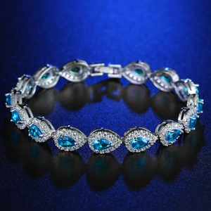 Macro detail of silver tennis bracelet featuring pear-cut sea blue cubic zirconia links