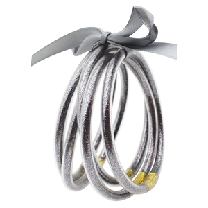 Detalle de tres pulseras de silicona con purpurina plateada y un lazo de satén gris
