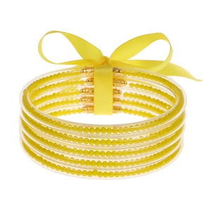 Set de cinco pulseras de gelatina de silicona amarilla con cuentas brillantes y un lazo