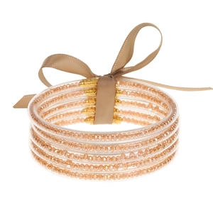 Detalle de 5 pulseras de silicona con cuentas oro champán y un lazo decorativo