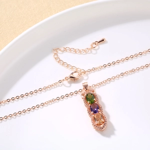 Detalle macro del collar en oro rosa con piedras de colores y cadena ajustable