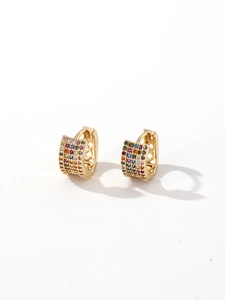 Nahaufnahme der goldenen Huggie-Ohrringe mit bunten Zirkoniasteinen und geometrischem Muster