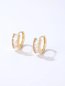 Detail of gold huggie earrings featuring vertical rectangular clear cubic zirconia stones