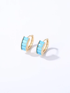 Detailed shot of gold hoop earrings set with five rectangular light blue cubic zirconia