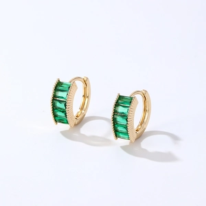 Golden huggie earrings set with rectangular green zircons and textured metal edges