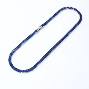 Detailopname van een zilveren tennisarmband met rechthoekige blauwe zirkonia stenen