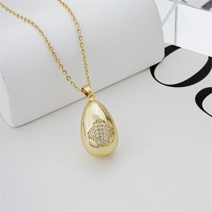 Dettaglio della collana a goccia dorata con intarsio a forma di quadrifoglio