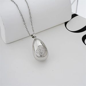 Dettaglio collana a goccia d'argento con intarsio a quadrifoglio su supporti geometrici