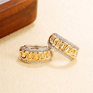 Dettaglio di orecchini bicolore oro e argento con pavé di zirconi e design a catena cubana