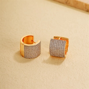 Macro shot of wide 18k gold-plated hoop earrings with micro-pave cubic zirconia crystals