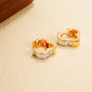 Macro view of 18k gold-plated flower earrings featuring zircon-set wide band detail