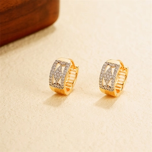 Detailed view of 18k gold earrings featuring micro-paved cubic zirconia and hollow rhomboids