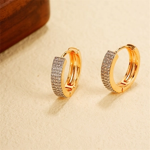 Detailed close-up of 18k gold hoop earrings with multi-row pavé-set cubic zirconia stones