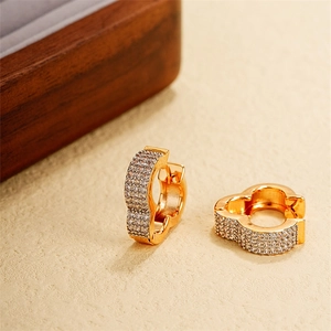 Dettaglio orecchini a cerchio placcati oro 18k con zirconi incastonati a trifoglio