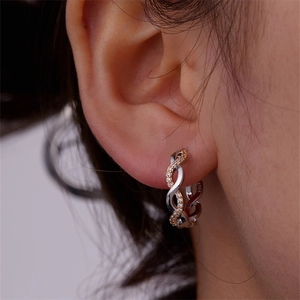 Macro view of S925 sterling silver twisted hoop earrings with white zircon on earlobe