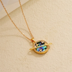 Macro view of 18K gold plated planet necklace with iridescent shell and zircon details