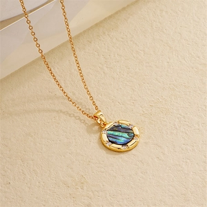 Macro detail of 18K gold necklace pendant with abalone shell and sparkling zircon stones