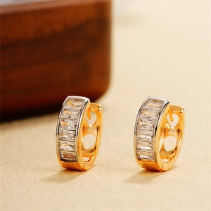 Vista macro degli orecchini huggie in oro 18k con zirconi rettangolari incastonati