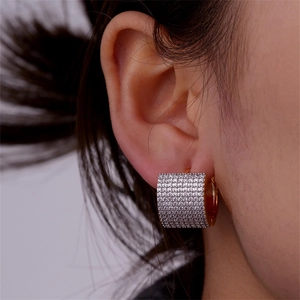 Close-up of luxury 18k gold plated wide hoop earrings with paved cubic zirconia crystals