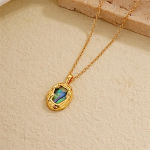 Macro shot of 18K gold plated heart necklace with iridescent abalone shell inlay