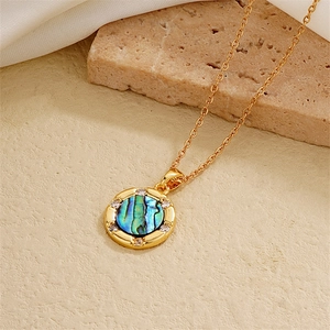 Macro shot of 18K gold plated heart necklace with zircon inlay and colorful abalone shell