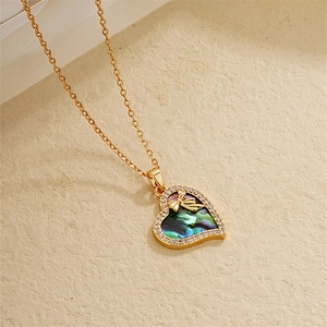 Macro shot of gold-plated heart necklace with abalone shell inlay and zircon details
