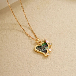 Close-up of 18K gold heart pendant with abalone shell inlay and colorful accents