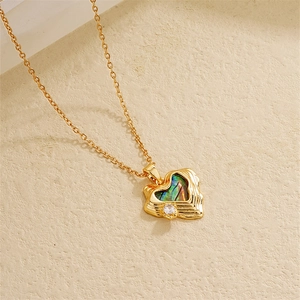 Macro shot of the 18K gold heart pendant featuring iridescent abalone shell and zircon