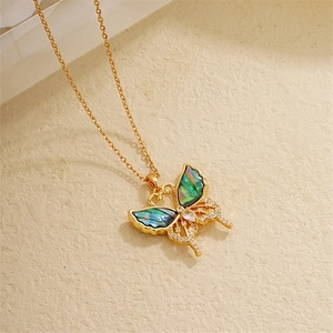 Detail of 18K gold butterfly necklace with abalone shell inlay and zircon accents