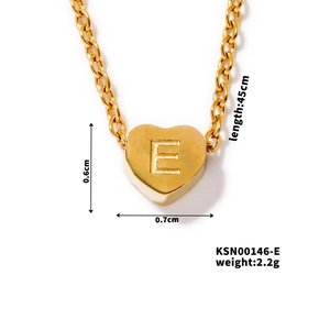 Macro detail of golden heart pendant with letter E engraving and sizing dimensions