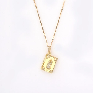 Collar de relicario de libro dorado con relieve de la Virgen y circonitas sobre fondo blanco