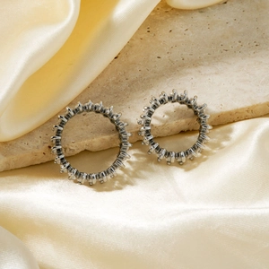 Dettaglio di orecchini tondi color argento con pavé di pietre in zirconia cubica