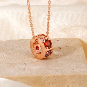 Squisita collana in oro rosa con ciondolo rotante in zircone colorato su base in pietra