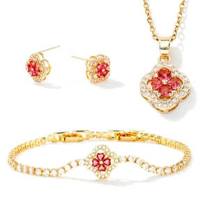 Three-piece jewelry set with gold clover pendant necklace, bracelet, and red stud earrings
