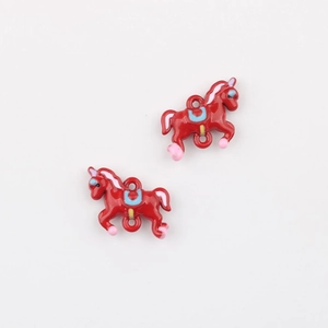 Detail shot of two red enamel carousel horse charms for DIY jewelry making kits