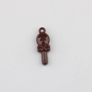 Macro detail of chocolate spoon pendant with glossy finish and cute bow for DIY jewelry