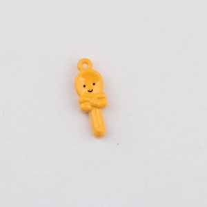 Close-up of yellow lollipop pendant with smiley face and bow for DIY jewelry making