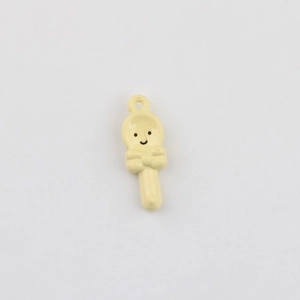 Detail of light yellow spoon-shaped pendant with smiling face and bow for DIY jewelry