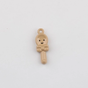 Close-up of a glossy beige spoon-shaped pendant with a smiling face and a bow tie