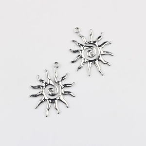 Detailed view of two silver-colored sunflower pendants with spiral center and ray design