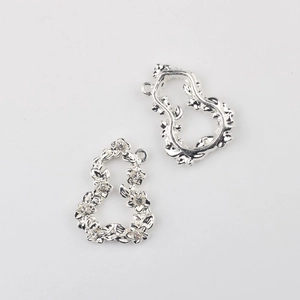 Détail macro de pendentifs couronne évidée en argent avec strass clairs pour bijoux DIY