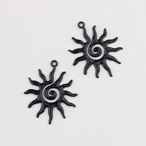 Close-up of black sunflower alloy charms with spiral center and glossy sunburst finish